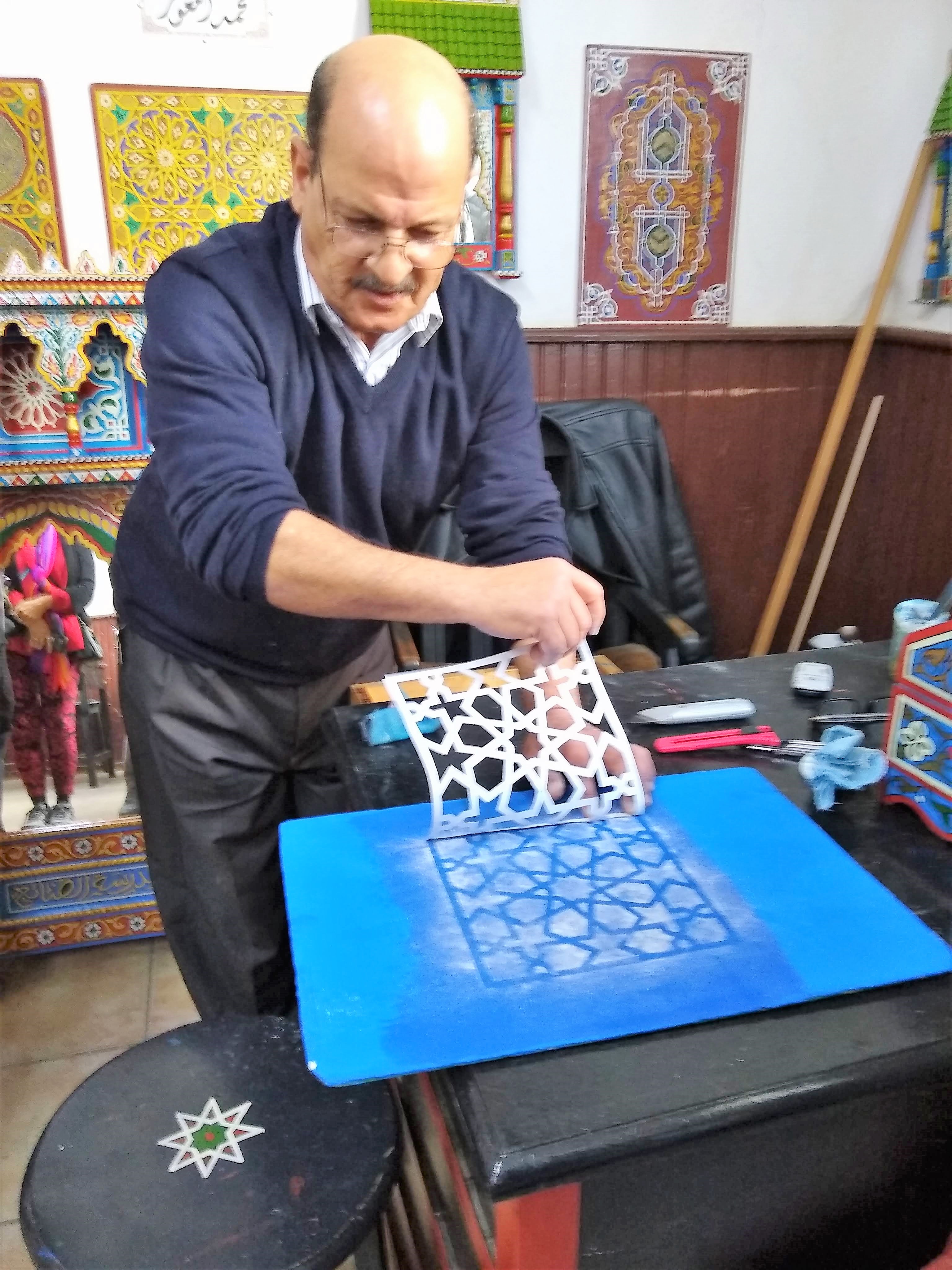 Instructor reveals stencil at Dar Sanaa, a traditional craft school in Tetouan