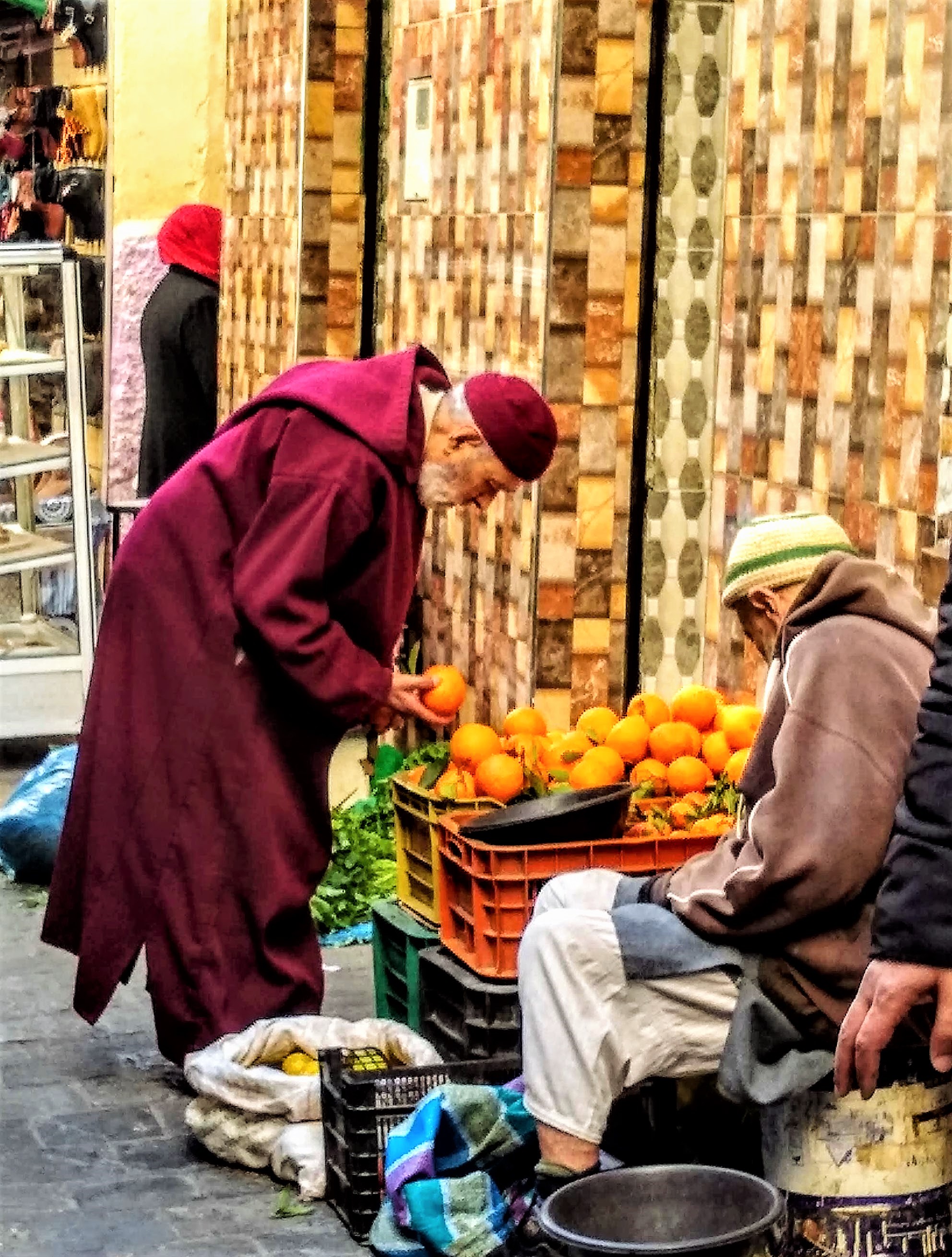 man in djellabah shopping for oranges in the Tetouan Medinat